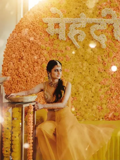 An ethereal, dreamy shot of the bride against the marigold backdrop, showcasing the simplicity and beauty of classic decor.