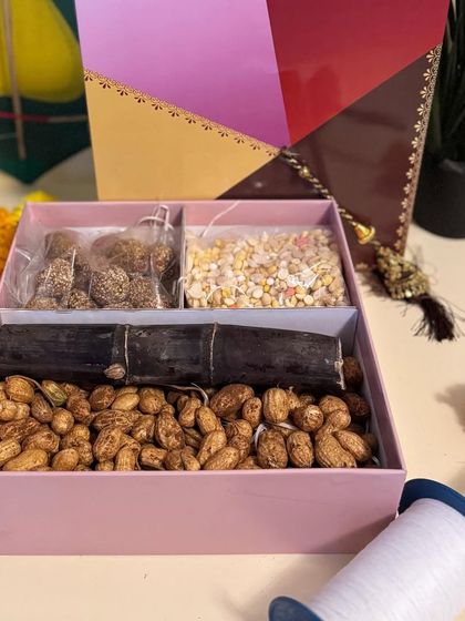 Our kite-themed Sankranti hamper box, opened to show the traditional treats inside: tilgul, Ellu Bella, sugarcane, and groundnuts.