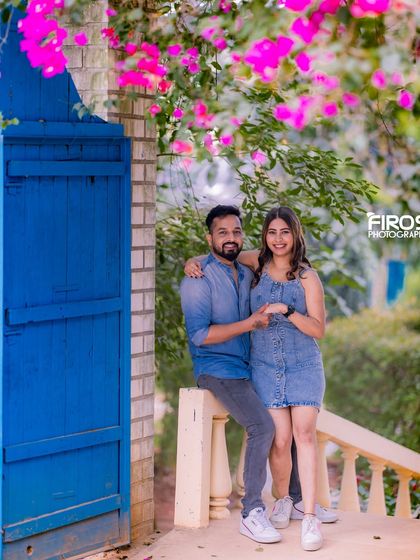 A sweet moment on a bridge with a blue gate and beautiful pink flowers, creating a romantic and colorful backdrop.