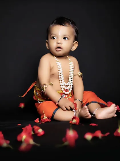 Our themed baby photoshoots are a client favorite. Here's a beautiful portrait from a 'Little Krishna' session, where we use dramatic lighting and simple props to create a timeless image.