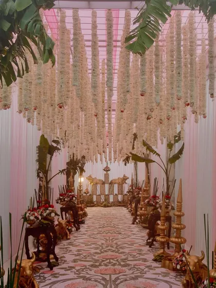 To honor tradition with elegance, I designed this South Indian wedding entrance. The aisle is lined with brass elements, banana leaf trees, and a ceiling of hanging tuberoses, creating a fragrant and culturally rich passage for the couple.