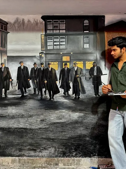 Standing with the completed Peaky Blinders mural. It is fulfilling to see a week of dedicated work come together in a piece that fills the entire wall with such a strong presence.