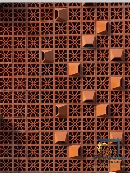 A close-up of a terracotta jali wall, showing the detail of the pattern and the natural, earthy texture of the clay blocks.