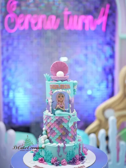 The mermaid cake in its underwater-themed party setting. The colors of the cake perfectly match the sparkling backdrop.