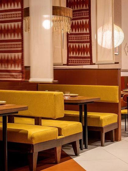 The seating at Tres Amigos is a mix of cozy booths and flexible tables. We used earthy yellow upholstery for the benches and custom-designed textile scrolls as partitions, creating a sense of intimacy while maintaining the restaurant's lively, communal feel.