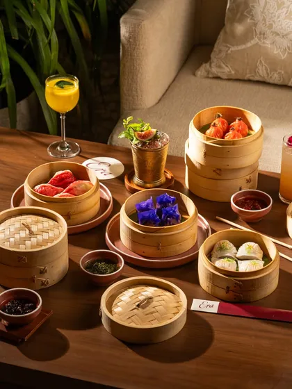 A moody, atmospheric shot of a dim sum dinner. The darker lighting creates an intimate and upscale feeling.