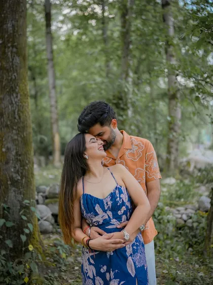 A tender hug from behind, capturing a moment of comfort and love amidst the tall trees of a forest.
