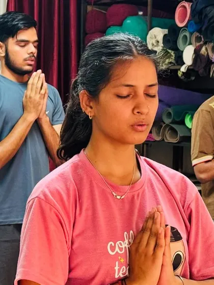Students stand in Anjali Mudra (prayer pose) at the beginning of a class, centering themselves before we begin our asana practice.