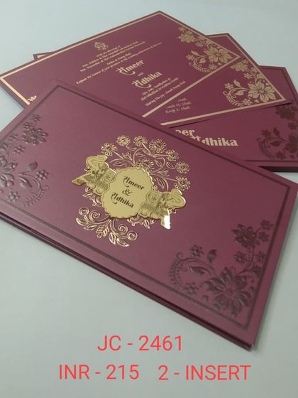 A beautiful magenta invitation with embossed floral details and a central gold nameplate. The rich color and intricate design make it a luxurious choice.