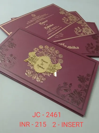 A beautiful magenta invitation with embossed floral details and a central gold nameplate. The rich color and intricate design make it a luxurious choice.