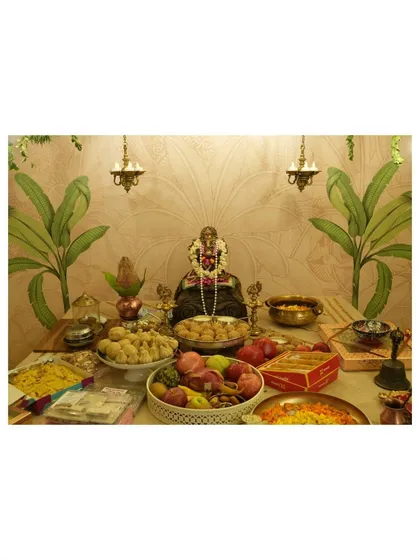 The heart of the celebration: the prasad and offerings table set before the Ganesha idol. We ensured the decor, featuring traditional brass lamps and a banana leaf motif wall, beautifully complemented the sacred arrangement of sweets, fruits, and religious items.