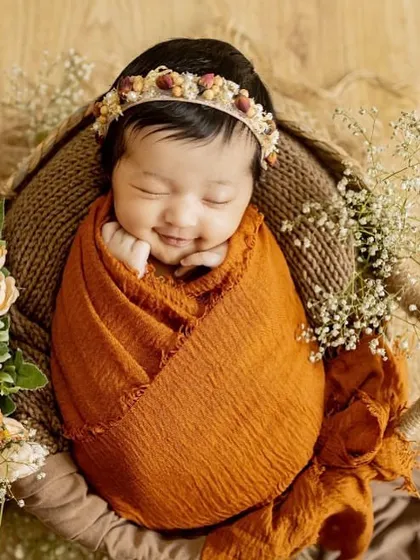 That sleepy newborn smile is just priceless. For my posed newborn sessions, I bring soft wraps, beautiful props, and a lot of patience to capture these peaceful, angelic portraits right in your home.