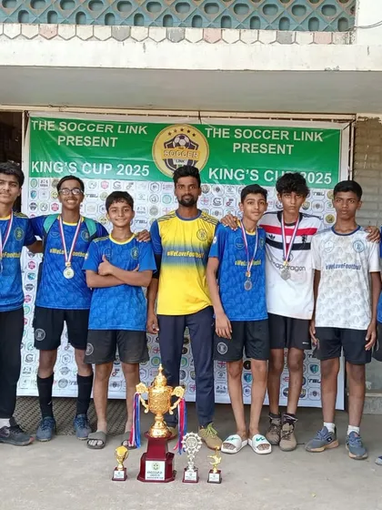 The U15 team poses with their coach and the runners-up trophy. This photo celebrates their credible performance and the valuable experience gained during the tournament.