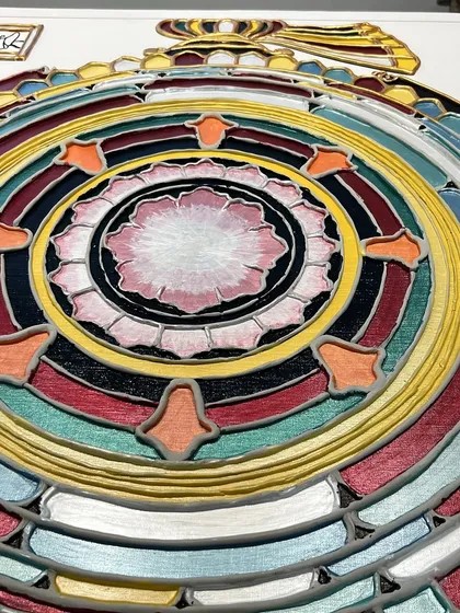 A detailed view of the painted "Siddha Chakra," showing the vibrant colors and the central lotus, which symbolizes purity and enlightenment.