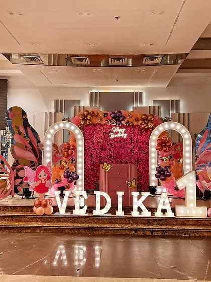 I enjoy creating unique and imaginative themes, like this butterfly and Paris combination for a first birthday. The stage includes a floral wall, large butterfly wings, an Eiffel Tower prop, and custom marquee letters for a truly one-of-a-kind look.
