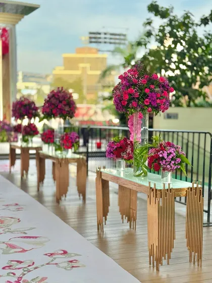 More views of the contemporary console tables adorned with large, vibrant floral arrangements, set against the backdrop of the city skyline.
