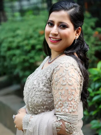 This is the "glass finish" skin everyone loves. I focused on creating a dewy, luminous base for my client, paired with shimmery eye makeup and a half-up hairstyle, perfect for her elegant reception lehenga.