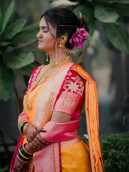 I love capturing the serene moments before the ceremonies begin. Here, the bride takes a peaceful second to herself, her traditional Maharashtrian attire, complete with a Nauvari saree and floral hair accessories, glowing in the soft light.