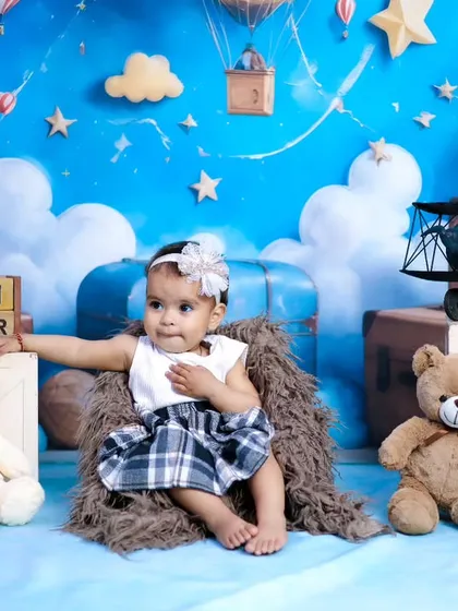 A one-year-old baby girl surrounded by teddy bears in our dreamy sky and clouds theme.