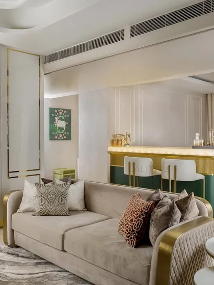 Another view of the integrated bar and lounge, highlighting the harmony between the spaces. The gold accents on the bar and sofa legs tie the design together, while the unique wall mirror adds an artistic touch.