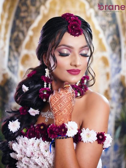 This close-up on the face shows the flawless makeup application and the delicate floral details.