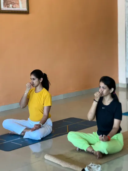 Two students practice pranayama together. The group energy of a class can be very supportive and motivating, especially when learning new techniques.