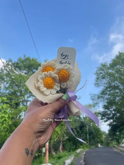 A final shot of the mini daisy bouquet, held up against a road, ready for an adventure.