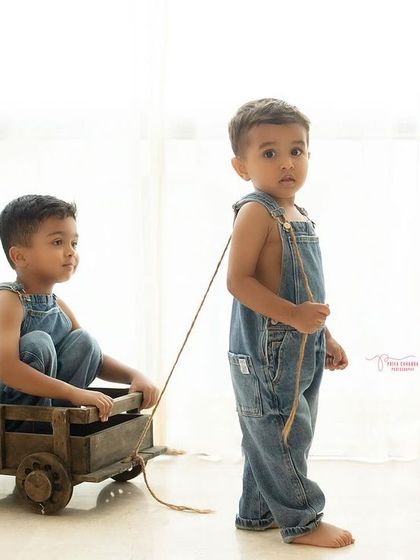 "Let's go, bro!" One brother pulls the other in a rustic wagon during a studio shoot. I love using props to encourage interaction and capture their personalities.