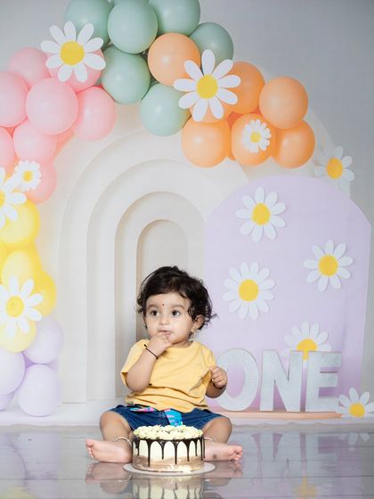 A cute shot of a baby enjoying his first taste of birthday cake.
