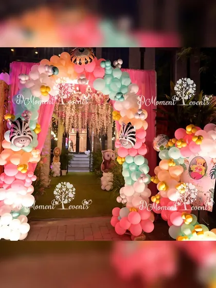 An enchanting entrance to the jungle-themed party. The balloon arch is decorated with zebra-head foil balloons, and the path is lined with hanging floral arrangements, creating a magical forest feel.