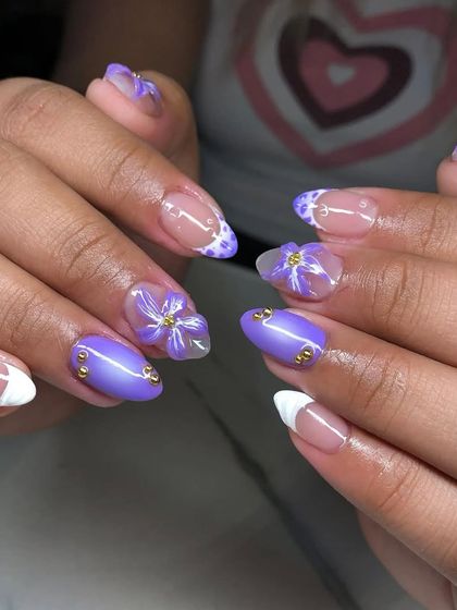 A lovely purple-themed set with a mix of solid color, French tips, and delicate 3D floral art.