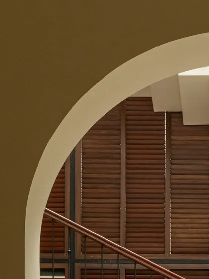 The graceful archways and louvered wooden shutters of Casa 503. These elements are part of a Spanish-inspired design that prioritizes natural light and ventilation, ensuring indoor comfort even in summer.