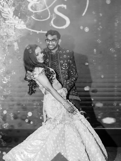 A beautiful black and white shot capturing a happy dance moment at the sangeet. The makeup is designed to look stunning in all types of lighting and photography styles.