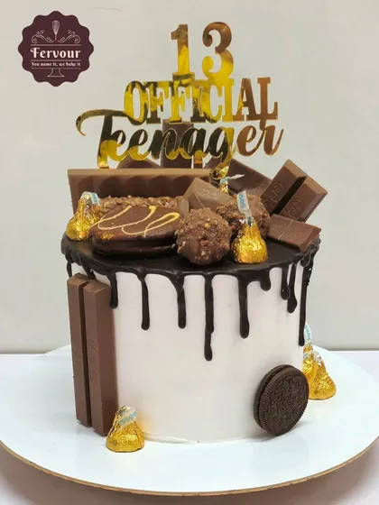 An "Official Teenager" chocolate overloaded cake for a 13th birthday. This drip cake is topped with a mountain of chocolates like KitKats, Ferrero Rocher, and Oreos.