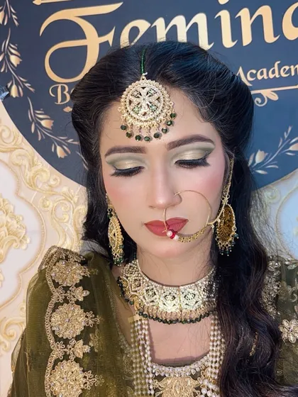 Another beautiful bridal look, this time with a focus on olive green eyeshadow to match the bride's attire. The look is completed with a large maang tikka and a traditional nose ring.