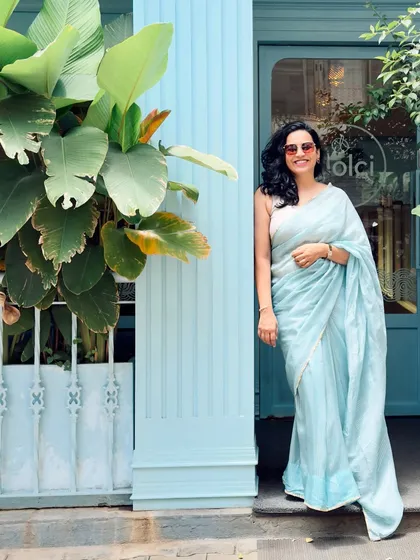 A full-length shot of the blue saree, showcasing its beautiful drape and flow. This photo gives a complete view of the outfit and the serene setting.