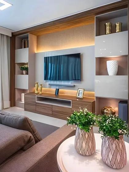 This living room TV unit features a balanced design with asymmetrical shelving. The combination of wood, white gloss cabinets, and integrated lighting creates a modern and dynamic entertainment hub.