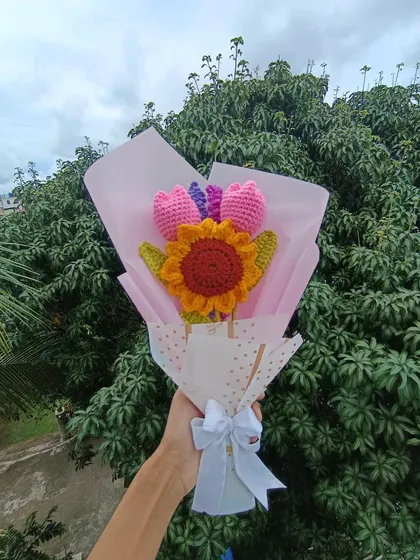 A custom bouquet featuring a sunflower and tulips, wrapped and ready.
