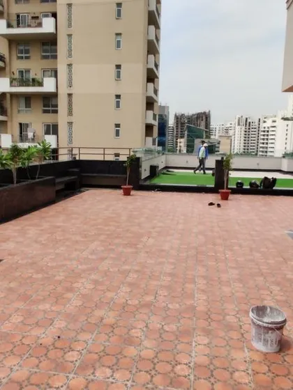 Another view of the Gurgaon terrace project. This side features terracotta-style tiles and built-in planters, creating a different zone for seating and gardening.
