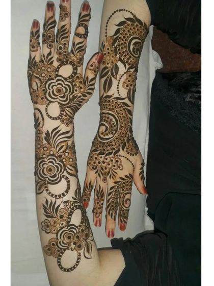 Two hands showcasing different but complementary Arabic-style floral and vine patterns.