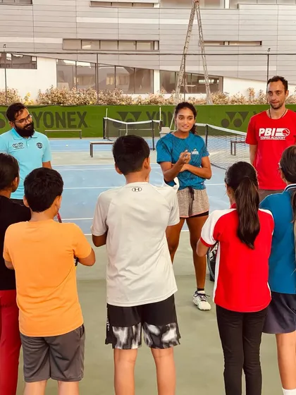 Coaches and students in a huddle with a visiting pro, creating an intimate and impactful learning experience. These sessions leave a lasting impression on our players.