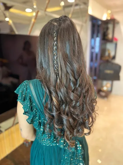 Serving bridesmaid goals in teal and soft glam. This hairstyle with soft curls and a chain accessory is chic and modern.
