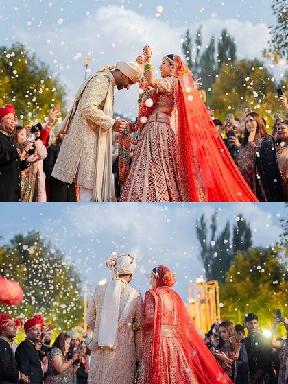 A magical moment during the Varmala ceremony. The bride's traditional red Tarun Tahiliani lehenga and the groom's elegant sherwani are a perfect match for this joyous occasion.