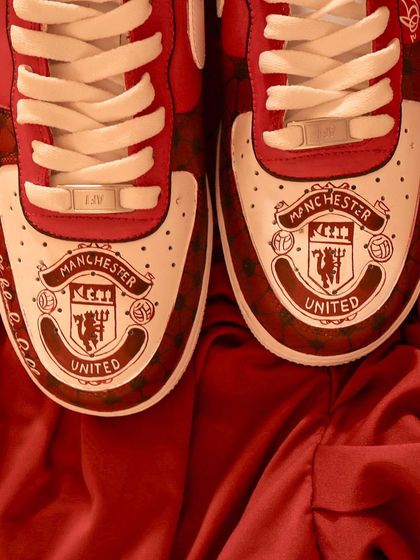 A top-down view of the Manchester United AF1s, showing the detailed club crest hand-painted on the toe box of each shoe.