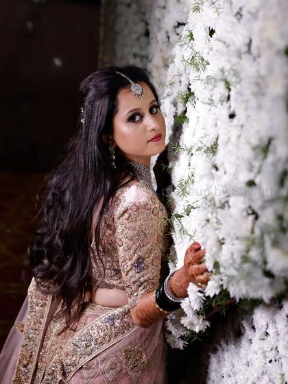 For her reception, we chose a soft and romantic look. The makeup features shimmery pink eyeshadow and a matching lip, which looks beautiful with her pastel pink lehenga and diamond jewellery.