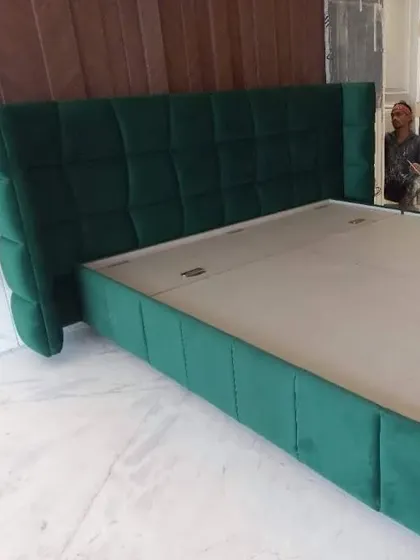 This bold, green upholstered bed features a channel-tufted wingback headboard. I enjoy working with vibrant colors and fabrics to create furniture that truly stands out.