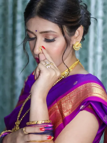 This artistic shot highlights the delicate nath and the beautiful eye makeup, key elements of a traditional Marathi look.