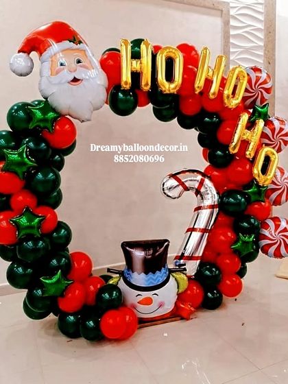A creative Christmas-themed balloon ring. This photo booth frame is decorated with Santa, snowman, and candy cane foil balloons, perfect for holiday parties.