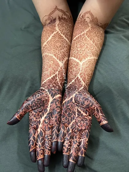 A full view of a gorgeous, dark floral stain. The design features a net pattern on the arms and dense floral work on the hands, all beautifully darkened.