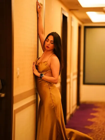 A side view of the golden gown, showing off its silhouette against a hotel corridor.